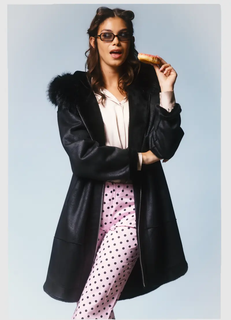 Look L31, Fall Winter 26/27: cappotto nero con collo di pelliccia e pantaloni a pois rosa