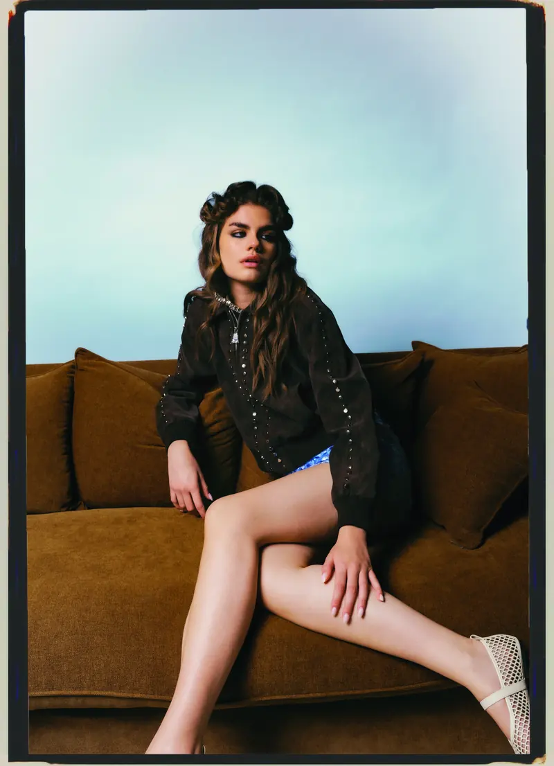 Look L5, Fall Winter 26/27: seduta sul divano, giubbotto nero