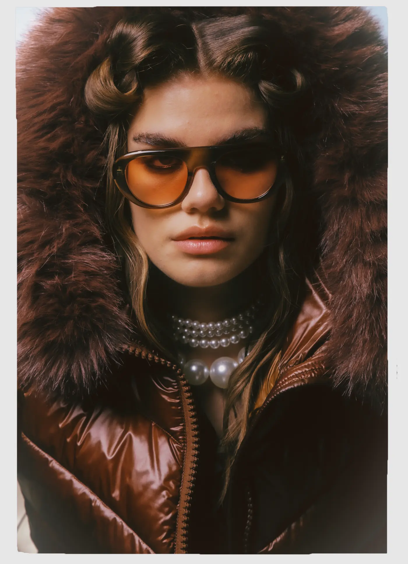 Look L55, Fall Winter 26/27: primo piano, piumino lucido marrone con cappuccio di pelliccia e perle